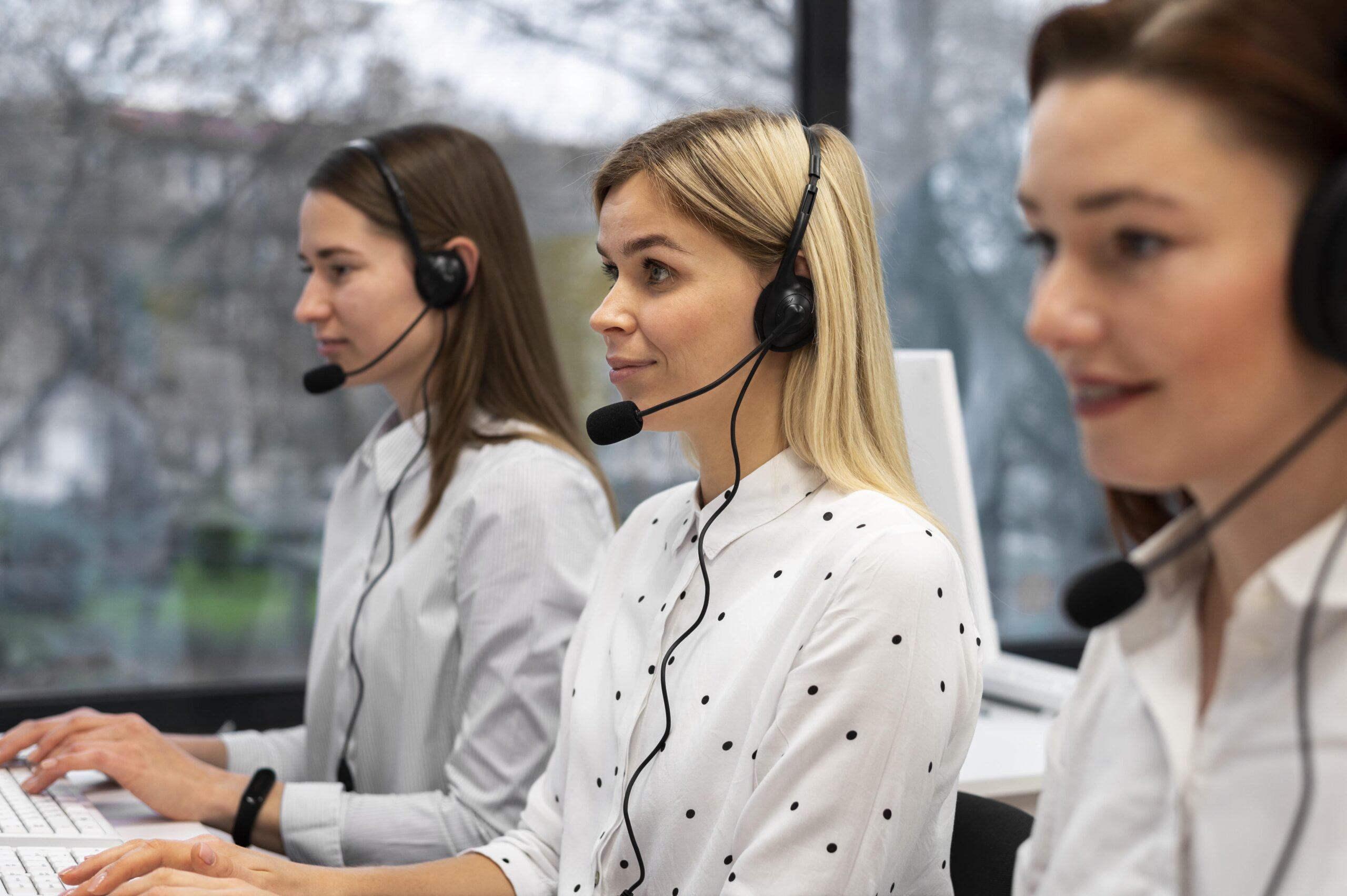colleagues-working-together-call-center-with-headphones-min
