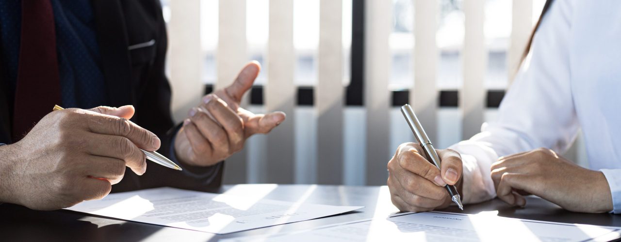 The home insurance salesman and the customer are signing an insurance agreement with their insurance company, accepting the terms and benefits. Home and real estate insurance concept.